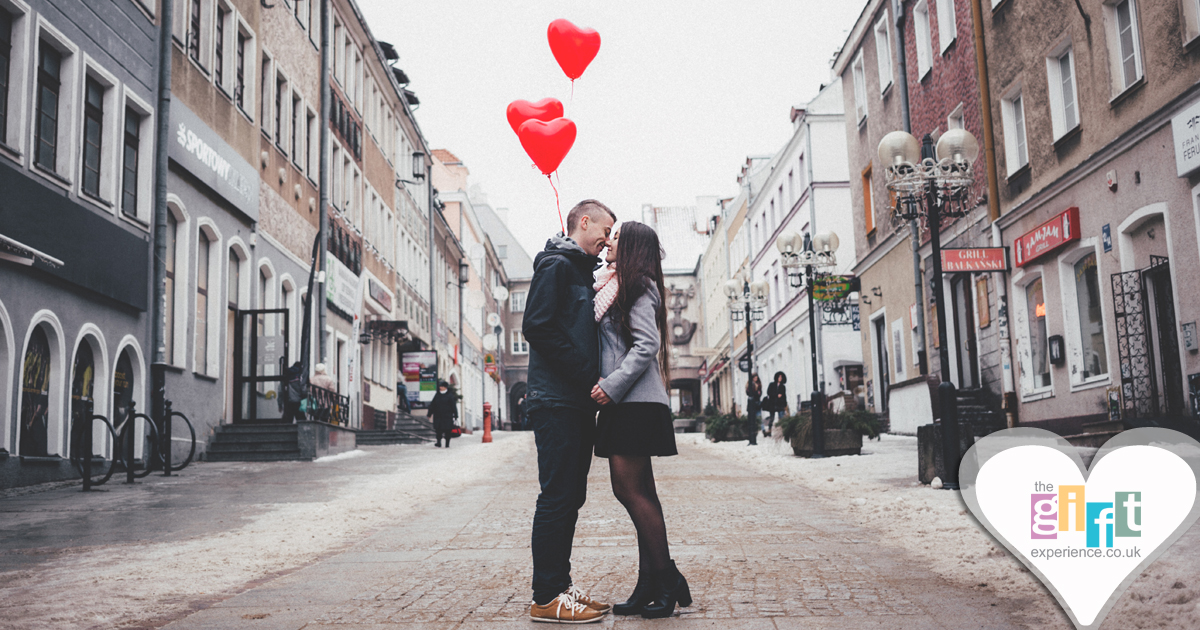 couple standing together holiding heart shaped balloons