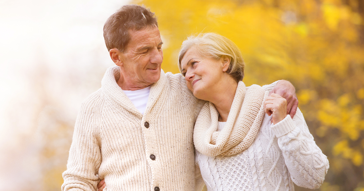 A man and wife looking at each other on an autumnal walk