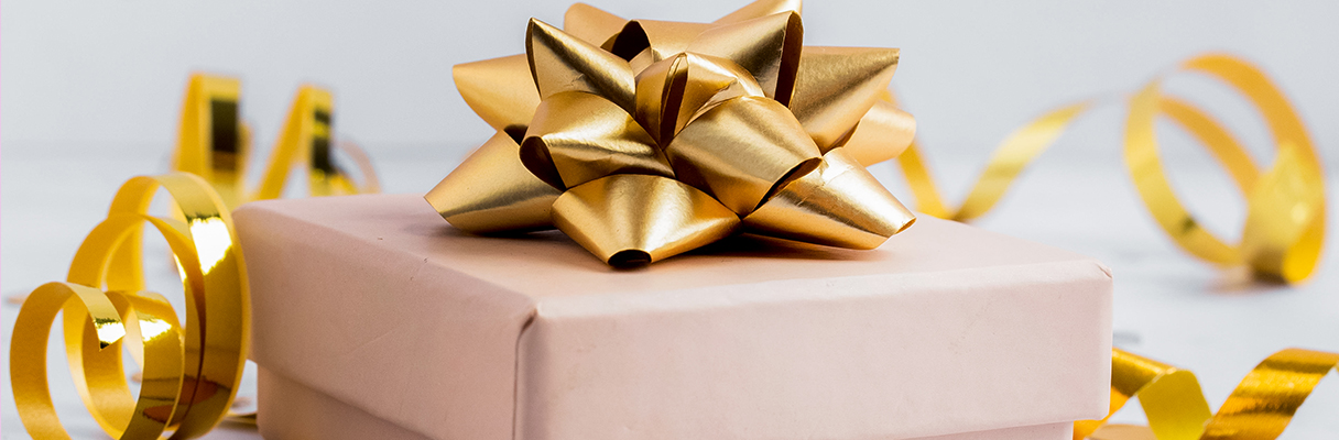 Elegant gift wrapped with gold bow and gold ribbon, perfect for anniversary presents