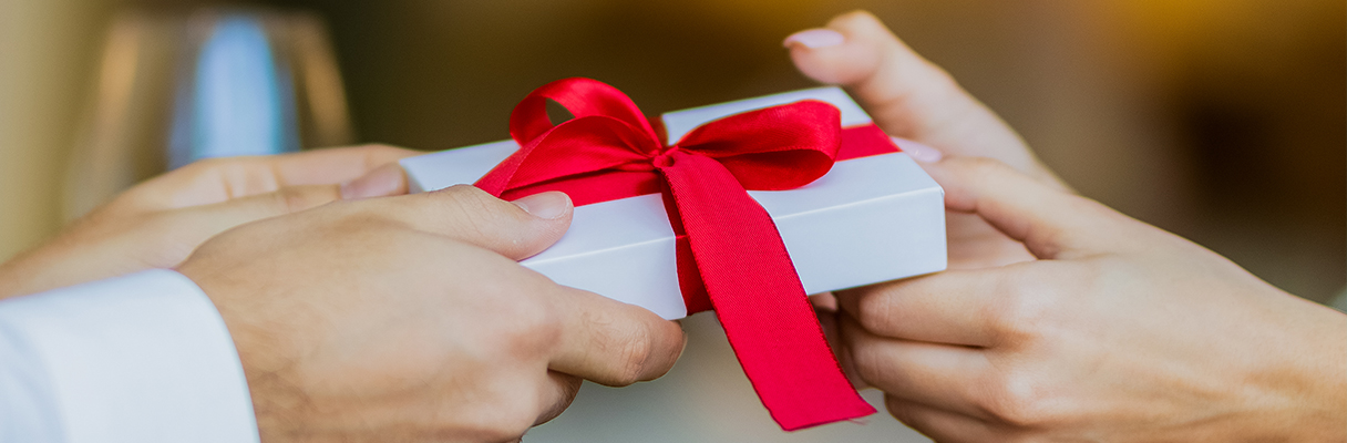 Three golden wrapped presents with golden baubles for 50th wedding anniversary Christmas gift celebration
