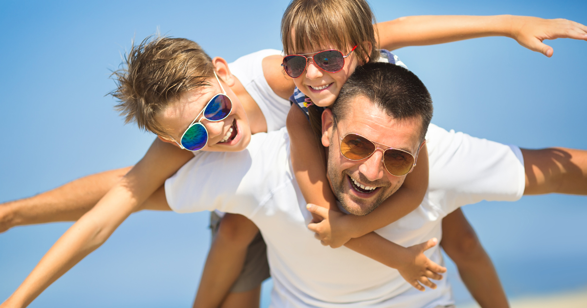 Dad and children playing on the beach on father's day