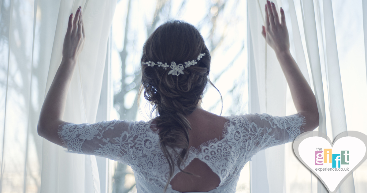 Bride looking out of a window on the morning of her wedding
