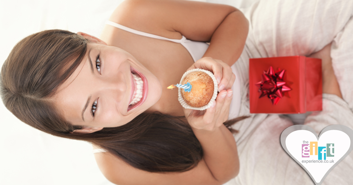 a women with a birthday gift and cupcake