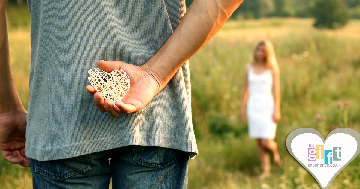 man holding a paper heart gift for his wife