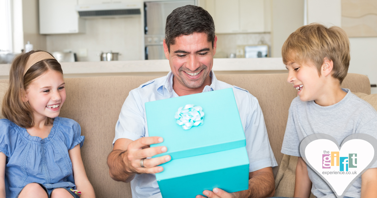 A dad opening a gift from his children on Father's Day