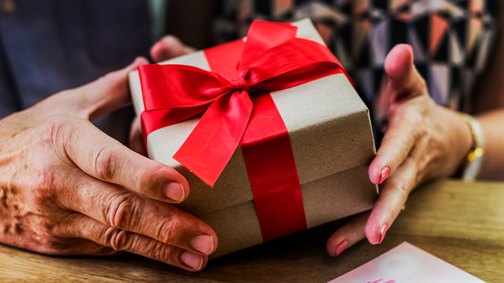 Senior husband and wife holding a thoughtful gift from their children, celebrating family love and special moments