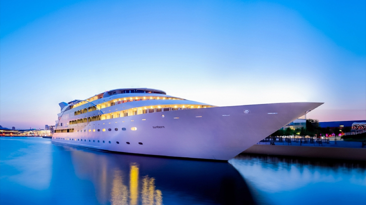 Luxury superyacht hotel docked in London with blue sky and serene river Thames views
