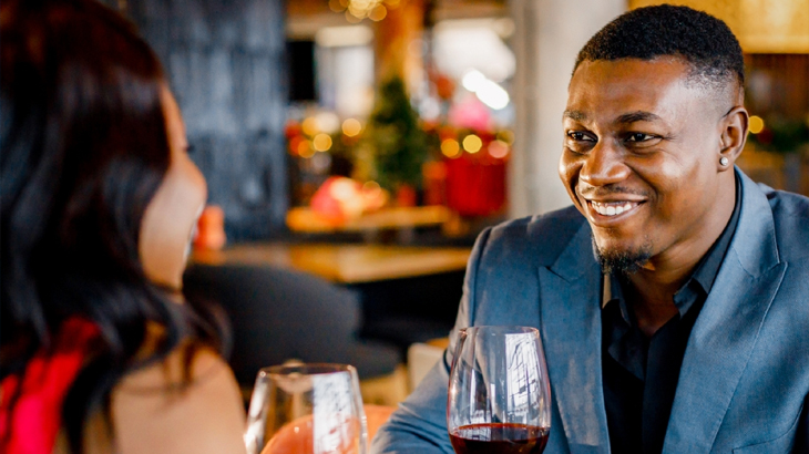 Couple savouring a meal and wine together during a one-night romantic getaway experience