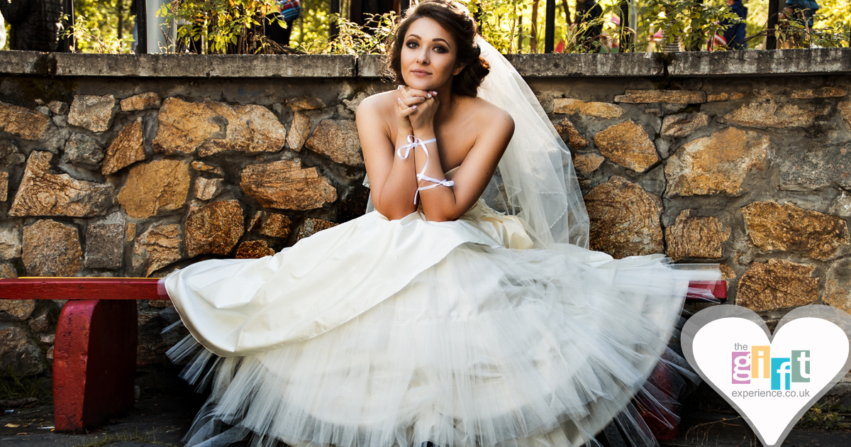 A woman sat on a bench in a wedding dress